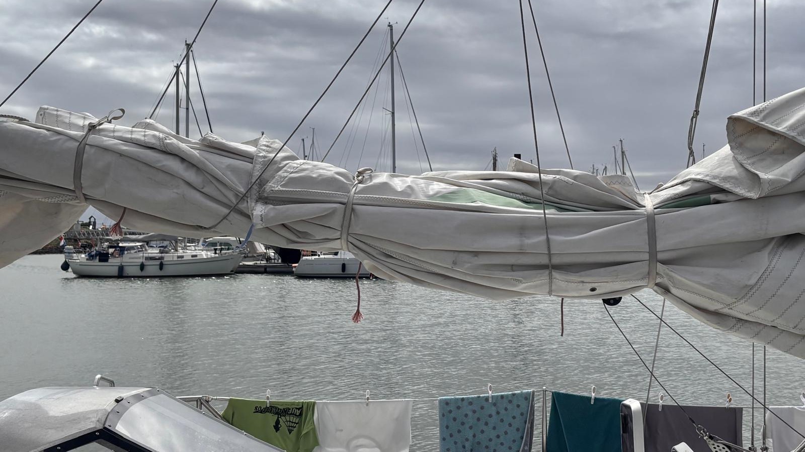 Zusammengebundenes Segel im Hafen mit Booten im Hintergrund