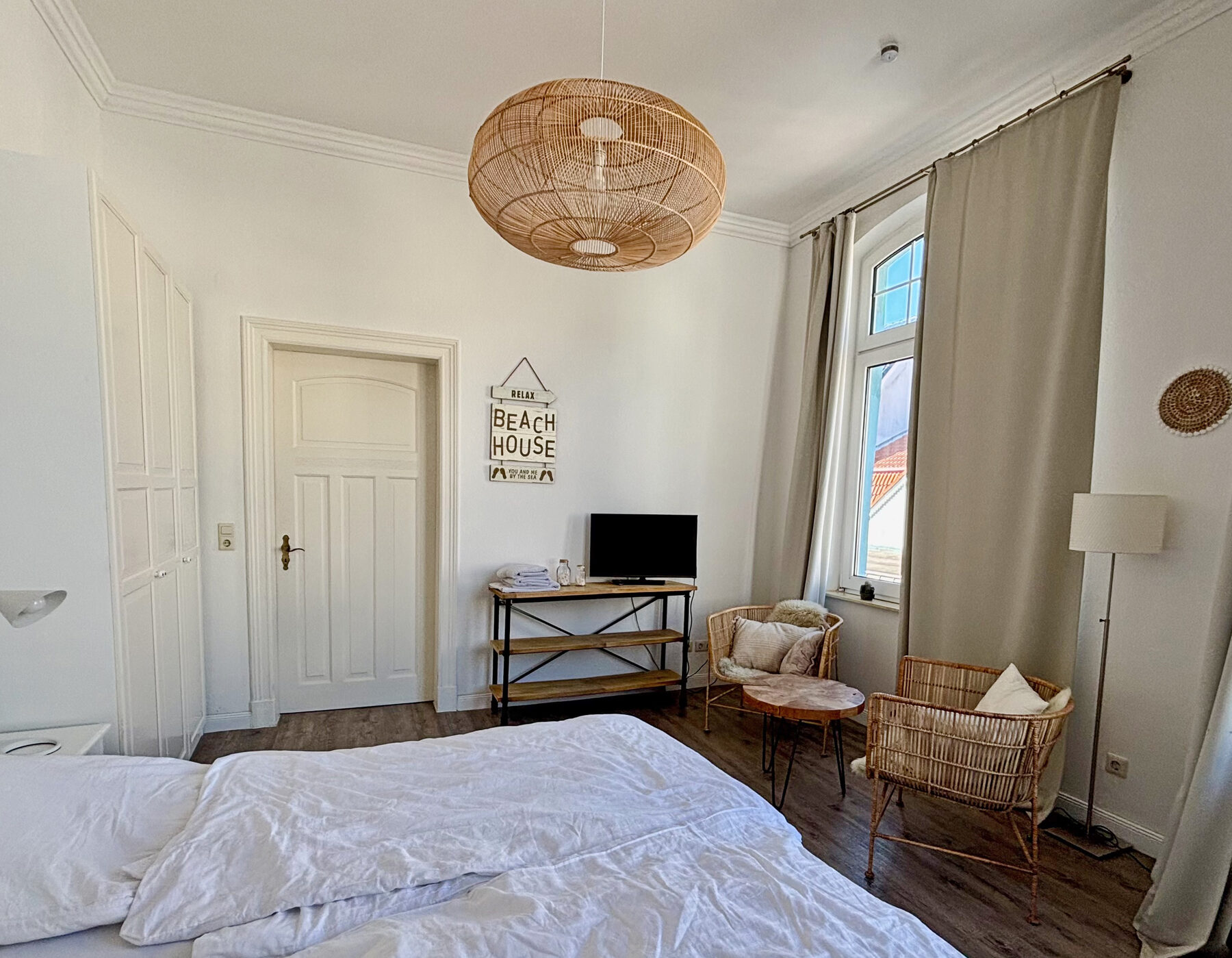 Schlafzimmer mit Rattan-Sessel und Sitzecke